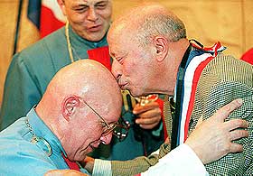 DE SKALLEDES KLUBB: Det finnes folk som jobber for � f� lov til � ha de blanke issene sine i fred. Her f�r sjefen for de skalledes forening, Henri Braye et kyss fra et nytt medlem under et seminar for skallede. 