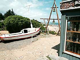 T�RRLAGT? Sjekta som aldri var i sj�en, hvor Pablo Neruda hver ettermiddag tok sine aperitiffer. I skipsklokkene ringte han
for � varsle naboene om at n� var han hjemme og n� var det klart for fest. I vinduet til h�yre noen f� av de mange flaskene som utgj�r hans samling.