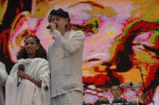 REDDET ETTER LIVE AID: Bob Geldof sammen med etiopiske Birhan Woldu under Live 8-konserten i 2005. Hun ble vist fram under den f�rste Live Aid-konserten som barn, og er ogs� p� plakaten bak p� scenen. I dag er hun kritisk til matvarehjelp fra utlandet. Foto: AFP/Paul Barker