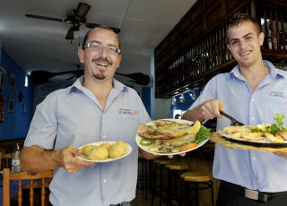  EL RESTINGA:   Manolo Motales Suayes  (til venstre) p� fiskerestauranten El Refugio frister med  Vieja ( som betyr gamla og er en vanlig type havabbor,  mens Jes�s Ascanio Cabyeya byr p� Gambas a la plancha. (grillede kjempereker)