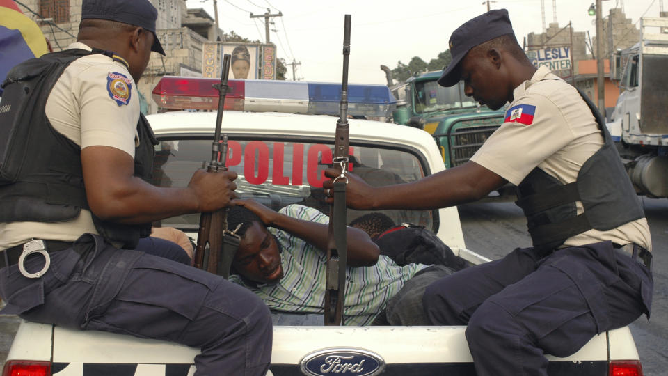 P�GREPET: En mann mistenkt for plyndring blir p�grepet av politiet i Port-au-Prince i forrige uke. Foto: REUTERS/St Felix Evens/Scanpix