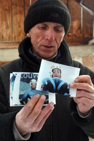 S�NDERKNUST: Nodar Kumaritashvilis far, David Kumaritashvili, holder opp bilder av s�nnen hjemme i Bakuariani. Faren forteller at familien er s�nderknuste etter s�nnens tragiske bortgang.Foto: SCANPIX/EPA/ZURAB KURTSKIDZE