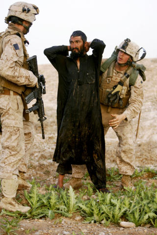 VANSKELIG � SKILLE: For NATO-styrkene vil det v�re en utfordring � skille Taliban-oppr�rere og sivilbefolkningen. Denne bonden, som ble mistenkt for � v�re i samarbeid med Taliban ble gjennoms�kt og sluppet fri. Foto: AFP PHOTO/PATRICK BAZ/SCANPIX