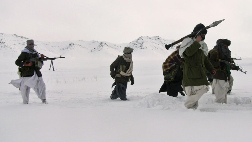 TUNGT BEV�PNET: Her er tungt v�pnede soldater fra Taliban p� marsj i de afghanske fjellene. Bildet er tatt p� ukjent sted i januar. Det er grupper som dette PST frykter kan f� st�tte fra ekstremister i Europa og Norge.  FOTO: SCANPIX