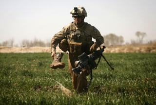 PATRULJE: En amerikansk soldat marsjerer gjennom en opiums�ker. Foto: AFP PHOTO/PATRICK BAZ