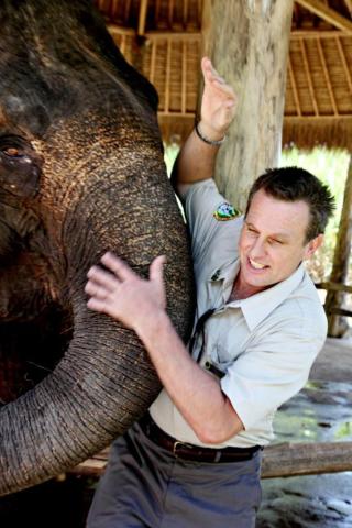 BLIR BORTE: Fagekspert i Bali Safari and Marine Park, Tim Husband, er bekymret for dyrenes fremtid. Her leker han med en av Sumatra-elefantene i dyreparken. I Indonesia er det bare 1500 igjen av arten. Foto: Sveinung U. Ystad