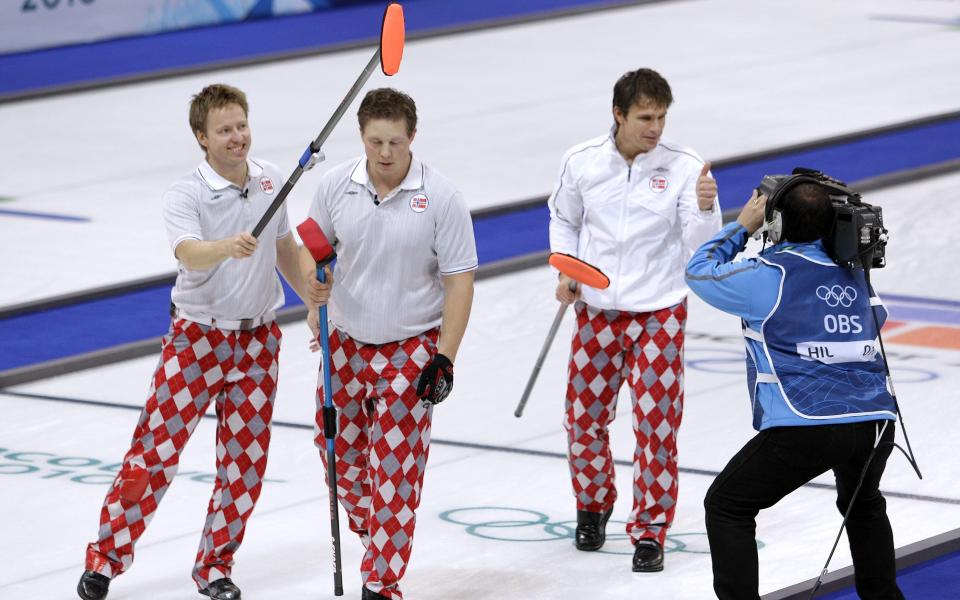 TOMMEL OPP FOR OL-FINALE: Skip Thomas Ulsrud gir tv-fotografen tommelen opp etter at Norge sikret plass i OL-finalen mot vertsnasjonen Canada. Torger Nergaard (t.v.) svinger kosten i glede.Foto: SCANPIX/AP Photo/Robert F. Bukaty