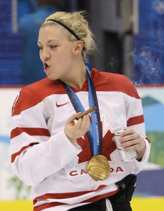  JENTE I R�YKEN:  Meghan Agosta tar en �resrunde p� isen med gullmedalje, �l og sigar. FOTO: AP/SCANPIX.