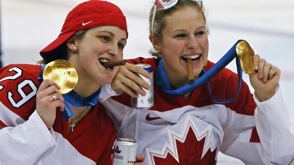 FEIRET: Matchvinner Marie-Philip Poulin og lagkamerat Tessa Bonhomme feiret OL-gull med sigarer og �l i ishockeyhallen i natt. Det er ikke alle like forn�yde med.Foto: SCANPIX/REUTERS/Scott Audette