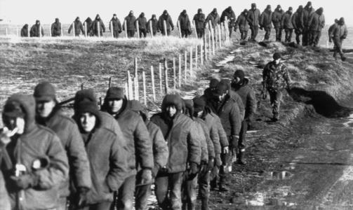 TAPTE: Argentinske soldater (foran) eskorteres 2. juni 1982 av britiske soldater etter overgivelsen og Falklandskrigen. Foto: AFP