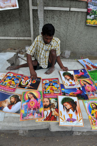 SLIK SKAL JESUS FREMSTILLES: Gateselger B. Mahesh viser fram Jesus-plakatene han har til salgs i Hyderabad. Foto: AFP/Noah SEELAM