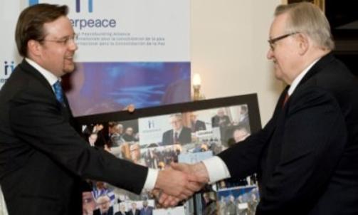 H�NDTRYKK: Generalsekret�r Scott Weber takker Martti Ahtisaari for innsatsen idet finnen g�r av som formann i organisasjonen. Han er n� �resformann, men var formann i �rene UD innr�mmer rapporteringssvikt fra. Webers l�nn, p� over 1,5 millioner, er uproblematisk for UD. Foto: Interpeace