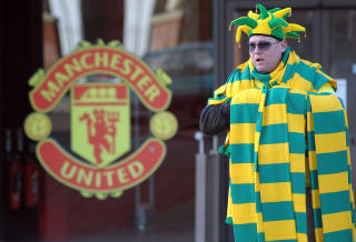 ST�TTER: En United-fan if�rt protestfargene gr�nt og gult avbildet utenfor Old Trafford. Supportergruppa Manchester United Supporters Trust (MUST) st�tter planene om et oppkj�p, og protesterer mot Glazers gjennom � if�re seg Newton Heats gamle farger p� kamp .Foto: AFP/Paul Ellis