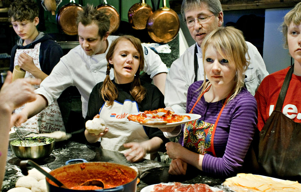 PIZZA-SKOLE: Det er litt kaos og mye konsentrasjon rundt kj�kkenbenken p� Viavang n�r Arne Brimi pr�ver � l�re ungdommer fra V�g� � bake hjemmelaget pizza.Foto: Mette M�ller