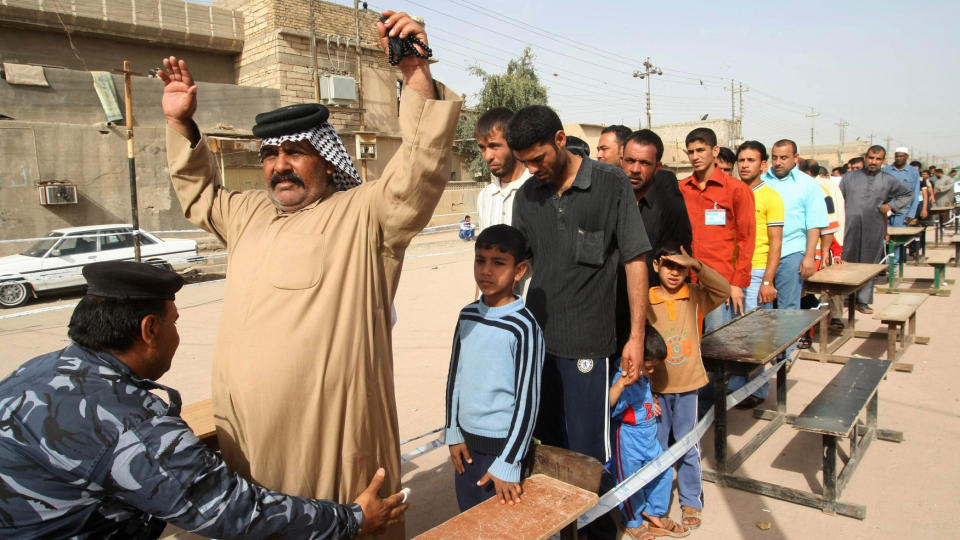 ANSPENT: P� tross av bombeangrep og trusler bruker mange stemmeretten i Irak i dag, som her i Basra. Alle blir kroppsvisitert f�r de ankomer stemmeurnene. Foto: ESSAM AL-SUDANI / AFP / SCANPIX