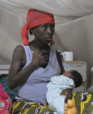 SIERRA LEONE: En kvinne holder en baby p� et sykehus i Freetown i Sierra Leone. I landet d�r hver �ttende gravide kvinne i forbindelse med svangerskap eller f�dsel, og av 1000 f�dte babyer d�r 282 i l�pet av de f�rste fem leve�rene. Kun 24 % av kvinnene kan lese og skrive. Sierra Leone regnes av CARE som verdens fjerde verste land for kvinner. Foto: AFP PHOTO / ISSOUF SANOGO / SCANPIX