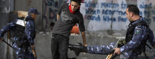 IKKE S� FREDELIG: Det er langt fra fredelig i de okkuperte omr�dene. Her sparker en palestinsk sikkerhetsvakt en palestinsk steinkaster under en demonstrasjon i Gaza. Foto: REUTERS/Eliana Aponte/Scanpix