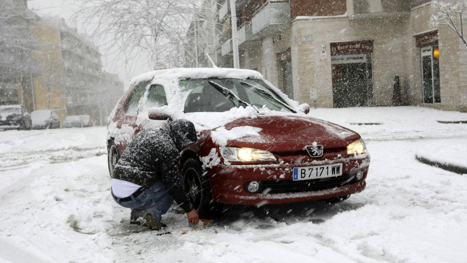  LAMMER MILLIONBY VED MIDDELHAVET:  En mann legger kjettinger p� bilen sin i Sant Feliu de Llobregat i n�rheten av Barcelona da Catalonia-regionen ble rammet av et kraftig sn�v�r. Foto: SCANPIX / Gustau Nacarino / REUTERS.