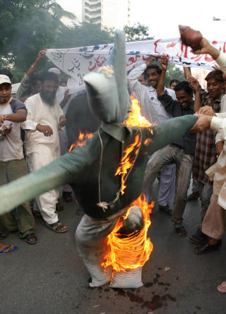 DEMONSTRASJON: 31. august 2007 protesterte en folkemengde i Karachi mot tegningene. Da brant de dukker som skulle forestille Vilks og Sveriges statsminister, Fredrik Reinfeldt. Foto: AP