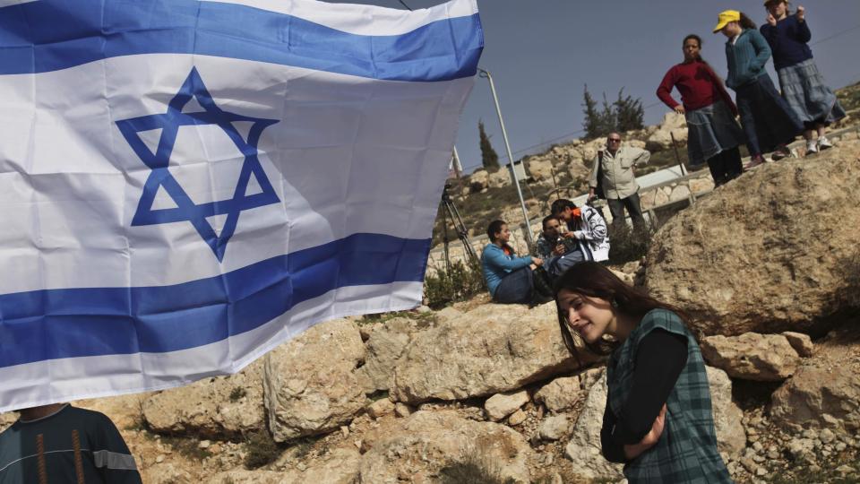 NY BOSETTING: Unge israelere ser p� mens grunnsteinen legges ned for nok en j�disk bosetting p� Hebron.  Foto: Scanpix