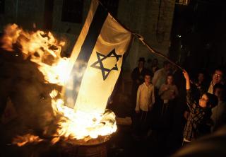 DEMONSTRERER OGS� MOT ISRAEL: Ultraortodokse j�der er motstandere av staten. Dette er medlemmer i gruppen Neturei Karta. De brente det israelske flagget under en feiring av en j�disk fest i Jerusalem i 2008. De mener j�der ikke skal ha en egen stat f�r Messias kommer tilbake. Foto: AP /Sebastian Scheiner