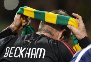 S�KALT POPUL�RT: David Beckham trakk p� seg det gr�nne og gule skjerfet som markerer protesten mot Manchester Uniteds amerikanske eiere. Banneret �Welcome back Green and Golden Balls� m�tte Beckham p� Old Trafford.Foto: SCANPIX/AP/Jon Super