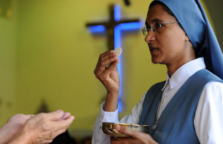 KRISTEN MINORITET: En malaysisk kvinne deltar i nattverden i Petaling Jaya. I januar m�tte malaysiske kristne opp tallrike til gudstjeneste for � protestere mot brannbomber mot flere kirker. Foto: AFP/Saeed KHAN