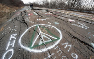 F�R STADIG BES�K AV TURISTER: Centralia er ikke forlatt. Stadig kommer ogs� bekymrede folk fra andre gruveomr�der for � se p� skadene. Foto: AFP/DON EMMERT
