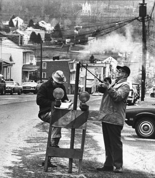 CENTRALIA APRIL 1981: Fortsatt blomstret Centralias sentrum. Men man begynte � ane at noe var galt. Den amerikanske gruvedirekt�ren John Stockalis  (til h�yre) og Dan Lewis putter et termometer gjennom et hull i hovedgata i Centralia. De skulle m�le varmen fra gruvebrannen under bakken. Foto: AP/Paul Vathis