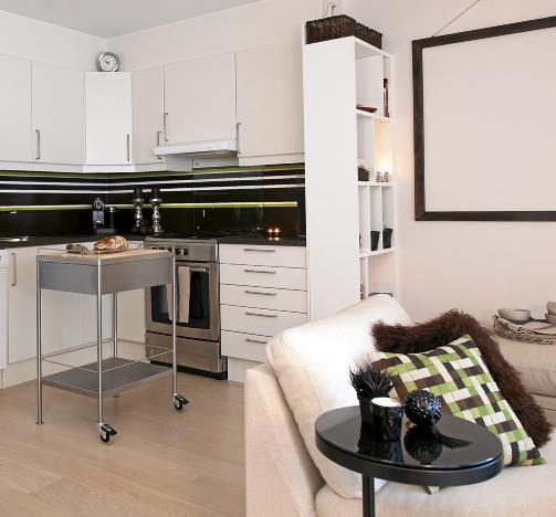 STUE MOT KJ�KKEN: Interi�rarkitekten frisket opp det enkle Sigdalkj�kkenet med asymmetriske striper malt p� en sjokoladebrun bakgrunn. Weng�farget, benkeplate fra HTH, Damixa �Profile� armatur, trillevogn fra Ikea og herdet glassplate fra Romerike Glass. Foto: Espen Gr�nli