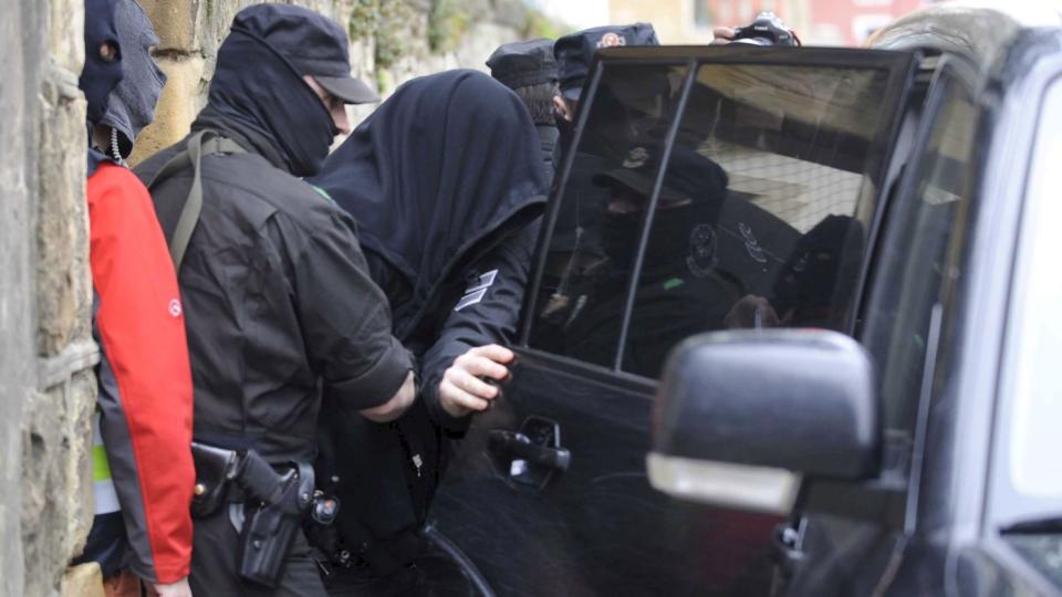 STORAKSJON: Maskert baskisk politi eskorterer en av de arresterte inn i en ventende politibil. Minst 69 er p�grepet i en europeisk storaksjon mot georgisk mafia. Foto: EPA/MIGUEL TONA/SCANPIX