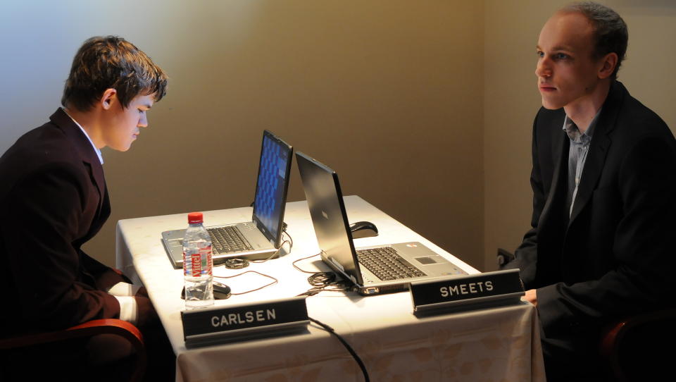 IKKE BIND FOR �YNENE: Men sjakkbrettet p� skjermene til Magnus Carlsen og Jan Smets er blanke. Posisjonene m� de huske utenat. Det eneste de f�r se p� skjermen er motstanderens siste trekk. Magnus slo Smets b�de i lyn- og hurtigsjakk i dag. Foto: Association Max Euwe