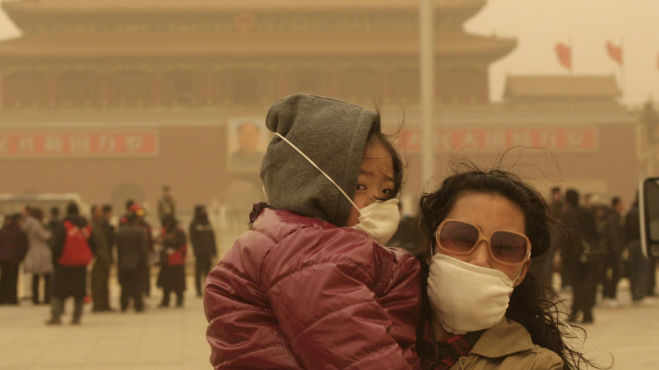 DEKKET AV SAND:  Turister har p� seg ansiktsmasker p� Tiananmen-plassen i Beijing. Den kinesiske hovedstaden ble rammet av en kraftig sandstorm l�rdag. Foto: REUTERS / Grace Liang / SCANPIX