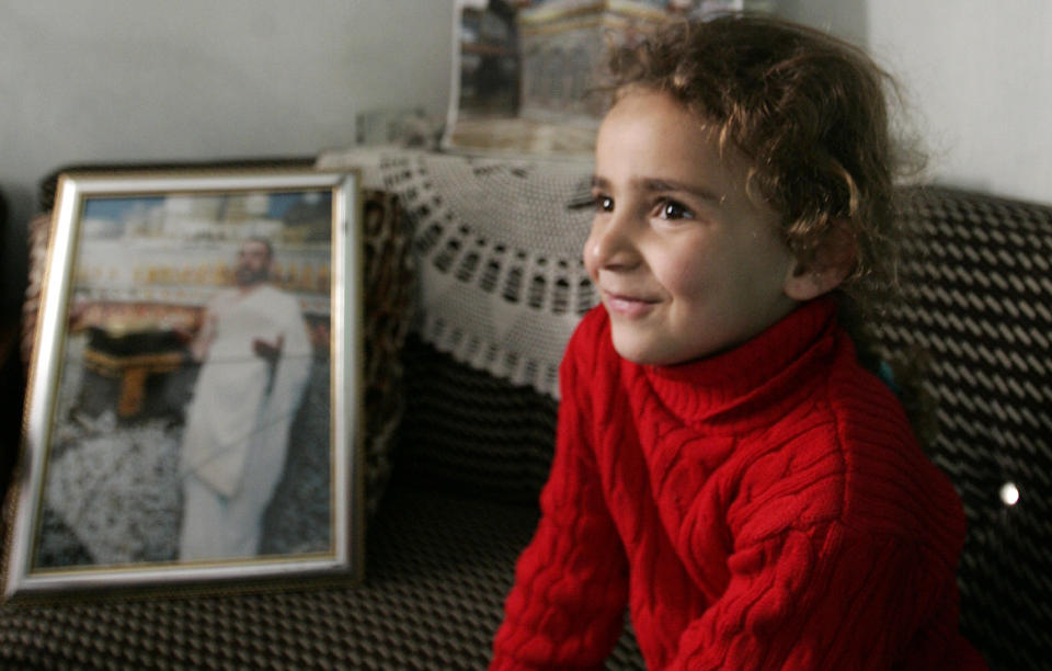 FEMBARNSFAR: Ali Sibats datter, Jamal, sitter ved siden av et bilde av faren. Den popul�re programlederen ble d�mt til d�den av en saudiarabisk domstol som mener han har drevet med trolldom. Foto: SCANPIX