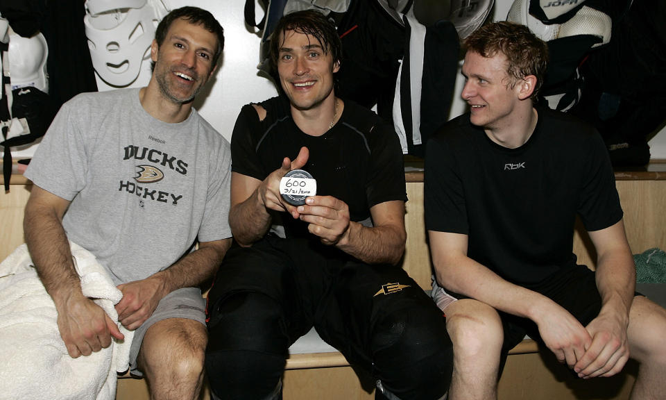 BARRIEREBRYTENDE: Teemu Sel�nne (midten) poserer med pucken han ekspederte i nettmaskene til sitt 600. m�l i NHL. Lagkameratene Scott Niedermayer (t.v.) og  Corey Perry i Anaheim Ducks poserte velvillig sammen med finnen i garderoben etter kampen mot Colorado Avalanche.Foto: SCANPIX/Debora Robinson/NHLI via Getty Images/AFP