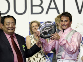 S�LV OG PENGER: William Buick mottar trofeet av styreformannen til l�pets st�rste sponsor, Lou Zhongfu. Foto: REUTERS