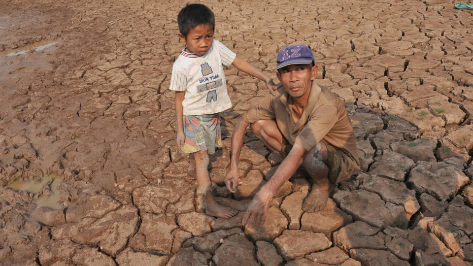 T�RKE:  Boden Phia Paokhammacham og s�nnen hans viser fram de t�rkerammede rismarkene sine i n�rheten av Mekong-elven i utkanten av Vientiane i Laos. En ekstrem t�rke har rammet s�r�stasia og s�rlige deler av Kina. Mekong-elvene er p� sitt laveste p� 50 �r. Foto: AFP PHOTO/HOANG DINH Nam