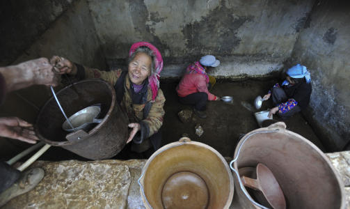 MANGLER VANN:  I Yunnan s�r i Kina mangler 8,3 millioner mennesker drikkevann. Innbyggerne i landsbyen Awang m� helt ned i bunnen av vanntanken for � f� med seg de dyrebare dr�pene. Foto: AP Photo.