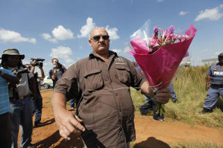 VISTE SIN RESPEKT: Apartheid-forkjemperens st�ttespillere kom med blomster til g�rden hans i dag. Foto: AP/Jerome Delay