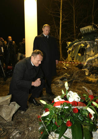 Vladimir Putin og Donald Tusk legger ned blomster p� ulykkesstedet. FOTO: SCANPIX