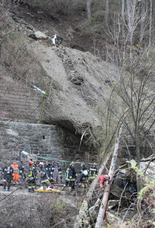  BRATT:  Jordskredet begravde ogs� veien under muren og dro med seg to biler. Nede i h�yre hj�rne en togvogn som stoppet mot et tre. Elva Adige ligger et stup under. FOTO: AFP/SCANPIX.
