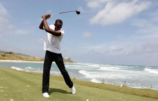 SLO UT I HAVET: Lite tyder p� at Bolt er like god med golfk�lle som med piggsko. Foto: Kevin C. Cox/Getty Images/AFP