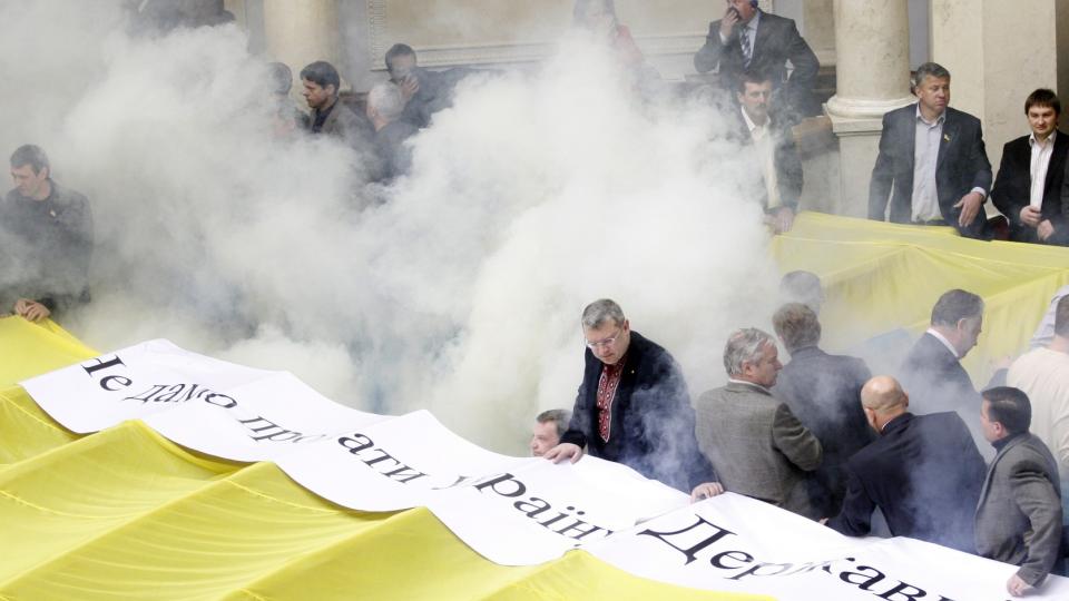 FRISK DEBATT: Nasjonalforsamlingen i Ukraina strevde i morges  med � f� kontroll over situasjonen etter at demonstranter aksjonerte mot den omstridte avtalen med Russland. Her er lokalet t�kelagt av r�ykbomber. Foto: MAXIM MARUSENKO / EPA / SCANPIX