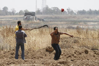 KASTET STEINER: Palestinere kaster steiner mot israelske styrker p� grensa �st i Gaza. Foto: AFP PHOTO/MOHAMMED ABED/SCANPIX