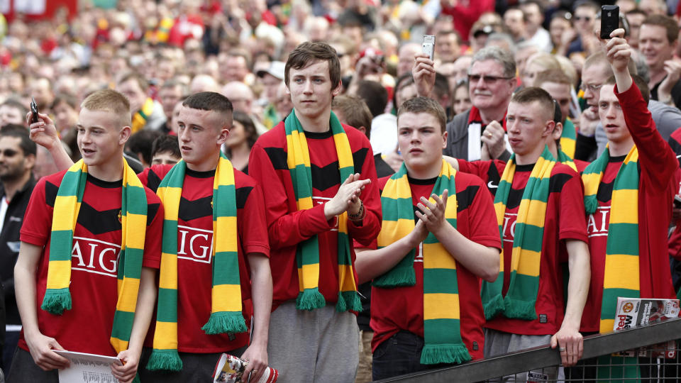 IKKE FORNY SESONGBILLETTENE: Medlemmer av Manchester Uniteds eldste supportergruppe har f�tt klar beskjed av ledelsen. Her kombinererer unge fans r�de drakter med gulgr�nne skjerf. Foto. REUTERS/Phil Noble