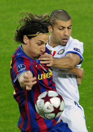 PAKKET INN: Og her er det argentinske Walter Samuel som bokstavelig talt tar h�nd om Zlatan.Foto: Manu Fernandez, AP/Scanpix
