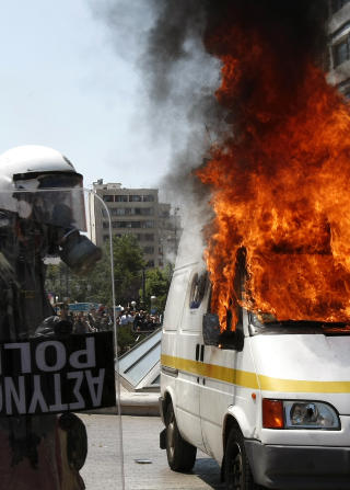 SATTE FYR P� BILER OG KNUSTE RUTER: B�de Athen og Thessaloniki har i dag hatt flere sammenst�t mellom politiet og demonstrantene. Deltakerne i de i utgangspunktet fredelige 1.mai-demonstrasjonene har satt fyr p� flere biler og knust butikkruter og minibanker. Foto: REUTERS/SCANPIX