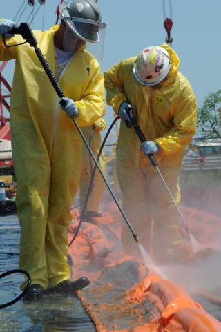 SPYLER: Arbeidere rengj�r en av de flytende barrierene som brukes for � samle opp olje og hindre spredning. Foto: EPA/PETTY OFFICER3RD CLASS PATRICK KELLEY/US COAST GUARD/SCANPIX