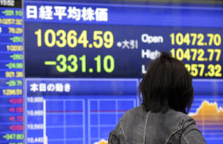 NYTT BUNNIV�: En fotgjenger sjekker aksjekursene i Tokyo tidligere i dag. Nikkei-indeksen gikk kraftig ned for andre dag p� rad, til det laveste niv�et p� to m�neder. Foto: AFP PHOTO / TOSHIFUMI KITAMURA