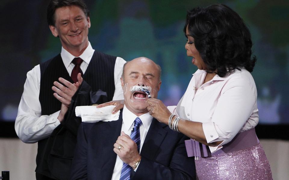BORT MED BARTEN: Talkshow-dronninga Oprah Winfrey fikk �ren av � ta den f�rste sveipen med barberh�velen. Foto: SCANPIX